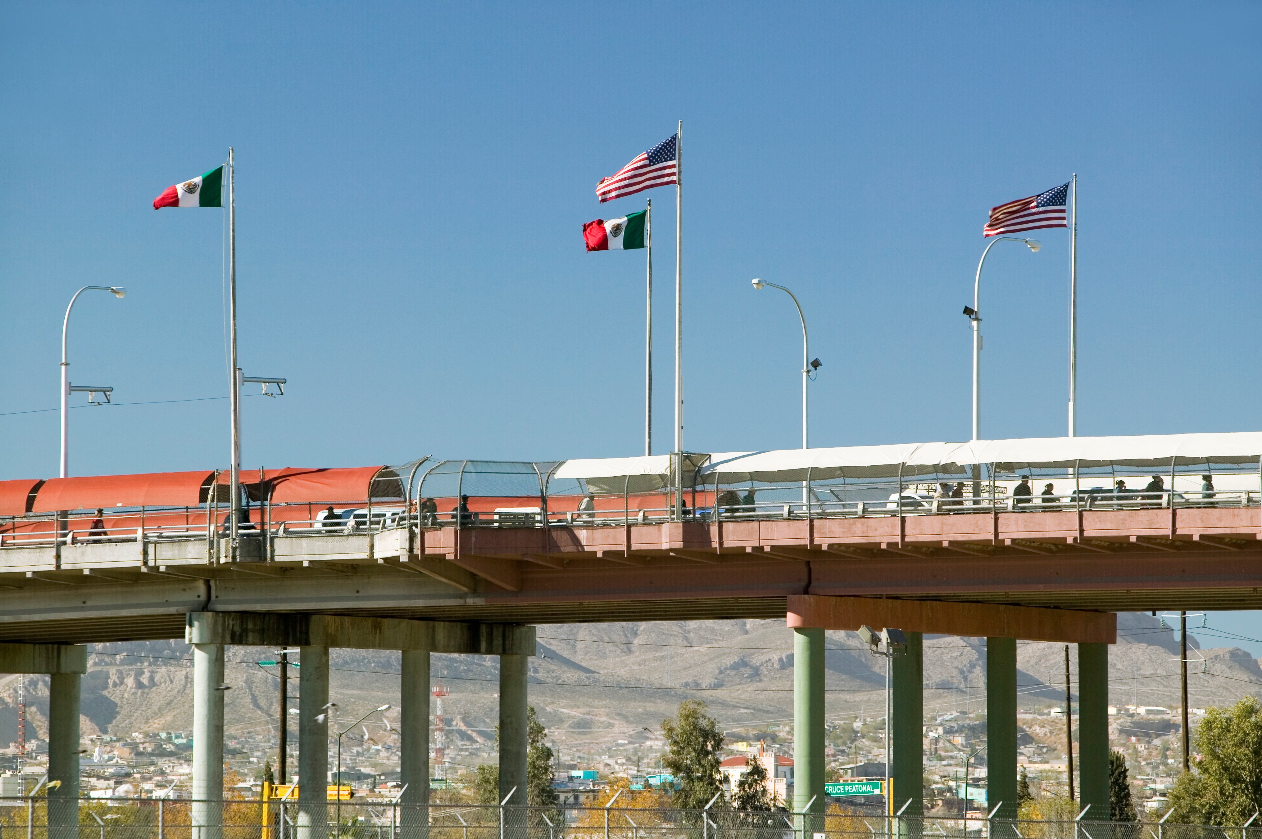 El Paso and Juarez border bridge with US and Mexico flags